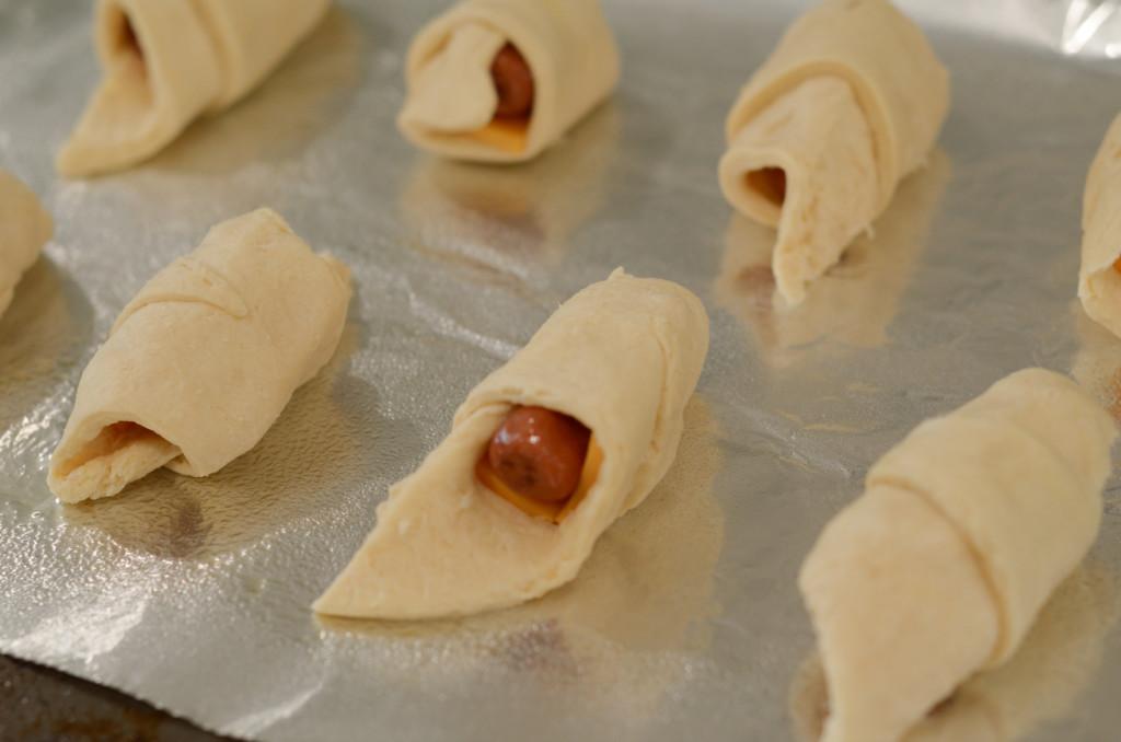 this image shows air fryer pigs in a blanket about to go into the air fryer.